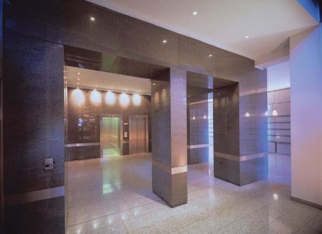 Eingangshalle in das Bürogebäude mit Gramablend verkleidet. In der gleichen Ausführung ist auch der gesamte Aufzugturm realisiert