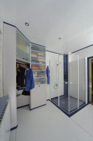 Kleider und Wäscheschrank mit geschlossenen Duschtüren, ganz rechts geöffnete Schiebetüre